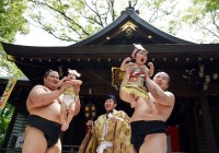 Sumo Wrestlers in Japan hold babies in a cent